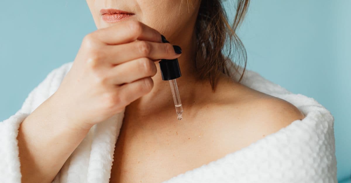 Cam şişede serum damlalığı ve cilt bakım rutini malzemeleri